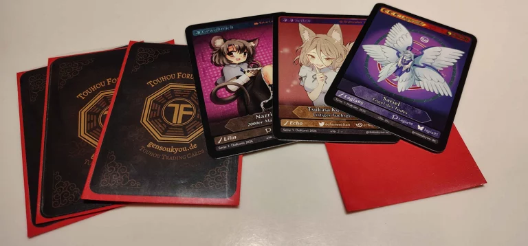 Drei eingepackte TFC-Karten und drei aufgedeckte mit Nazrin, Tsukasa und Sariel