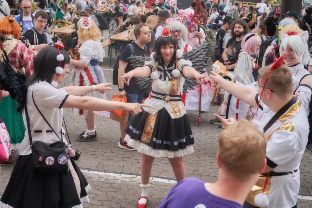 Drei Cosplayer, alle als Aya, zeigen beschuldigend aufeinander