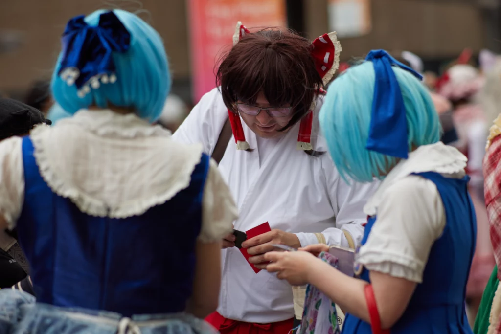 Drei Cosplayer (Cirno, Cirno und Reimu PC98) tauschen Trading Cards
